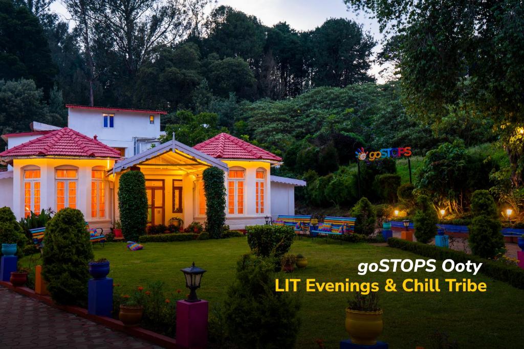 a house with lights on in a yard at goSTOPS Ooty in Ooty