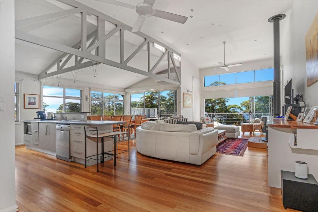 a living room with a couch and a table at Hyams Reflections Hyams Beach in Hyams Beach