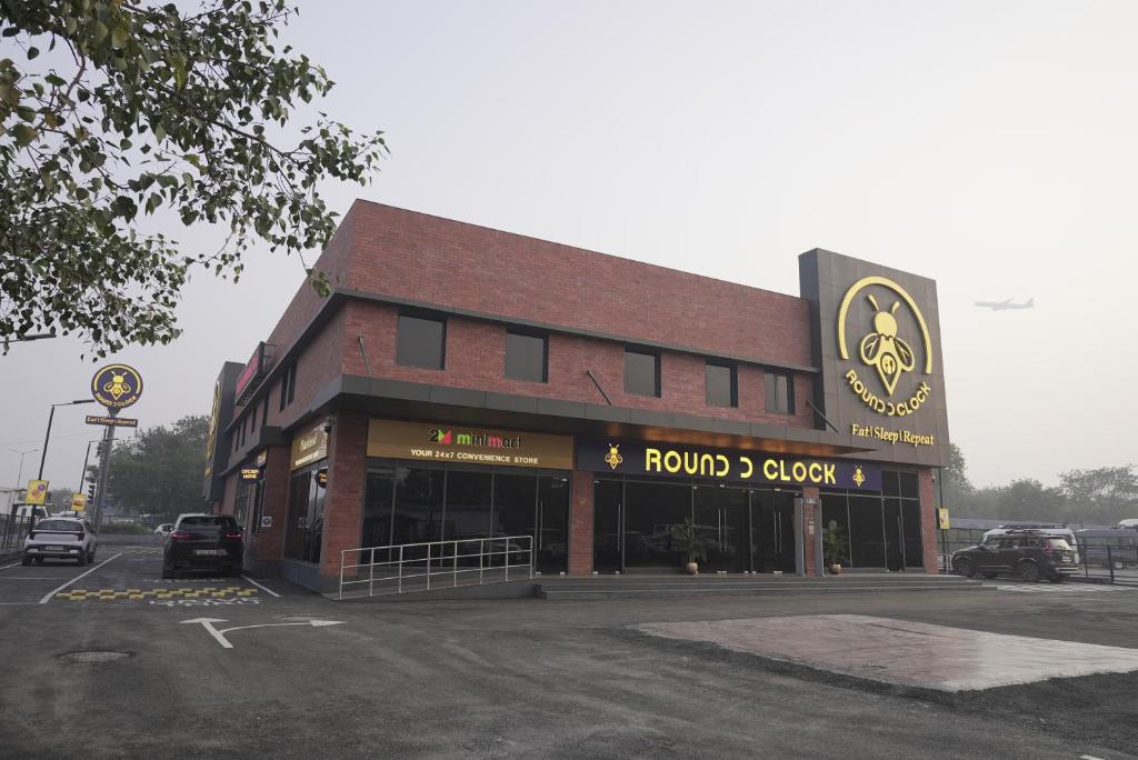a brick building with a round clock sign on it at Round D Clock, IGI Airport in New Delhi