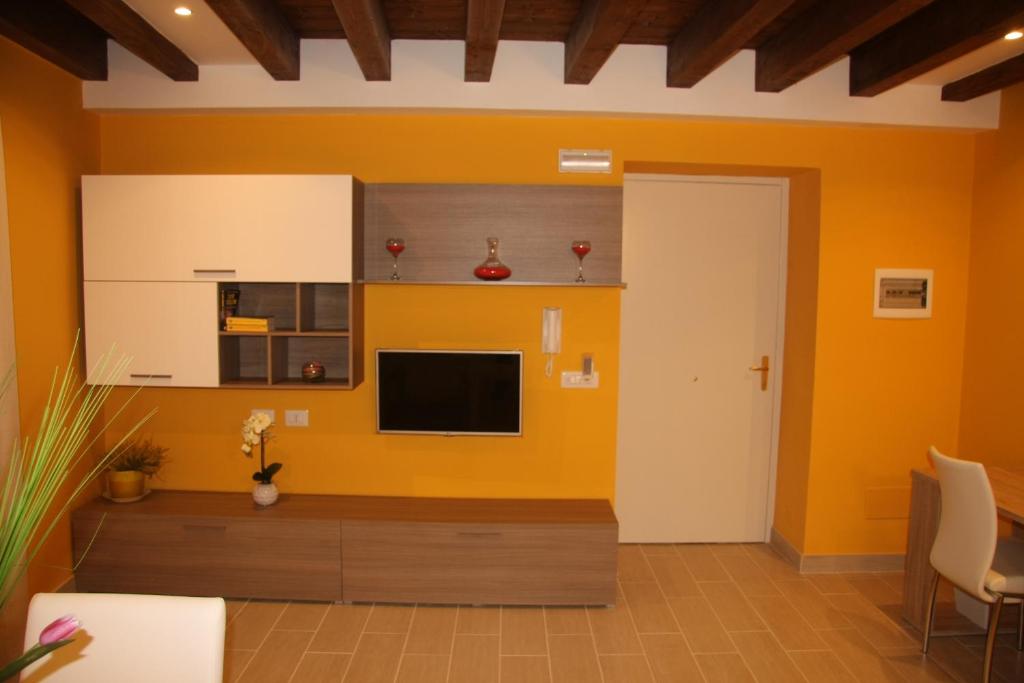 a living room with a tv and a yellow wall at Aretusa Apartments in Siracusa