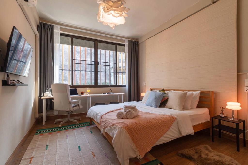 ein Schlafzimmer mit Bett, Schreibtisch und Fenster in der Unterkunft Walk2BTS, KingBed, FastWiFi, FreeLaundry, Netflix in Klong Toi