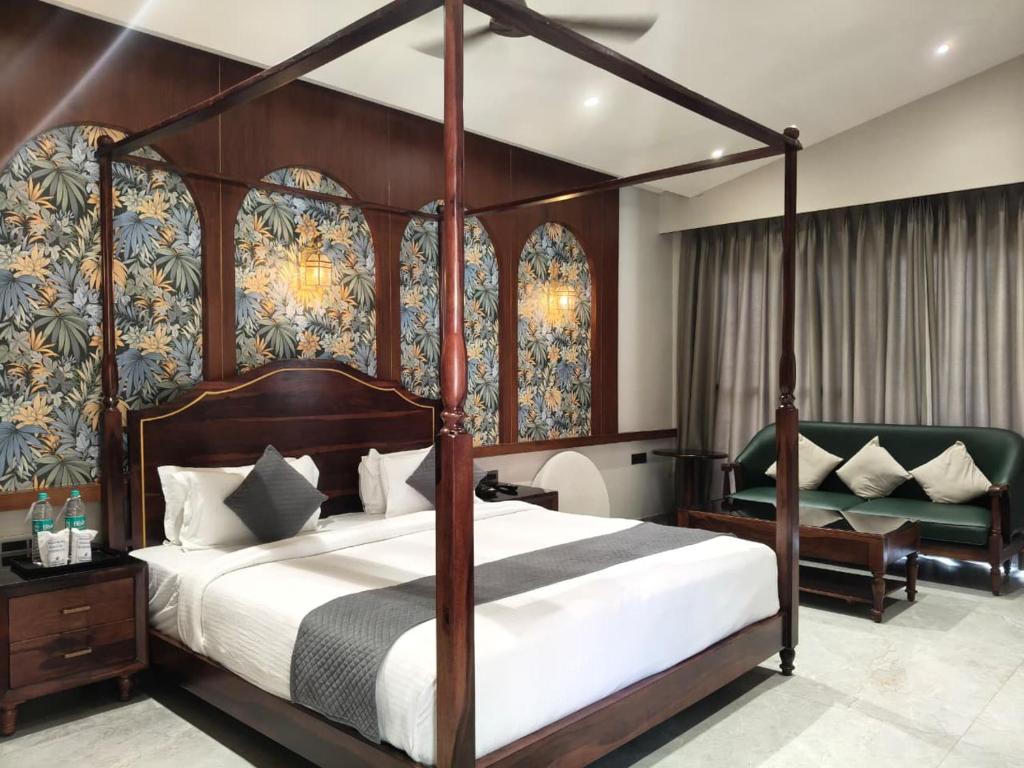 a bedroom with a canopy bed and a chair at Vaikunth Village Resort in Raipur