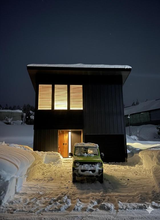 a car parked in front of a building in the snow at Myoko Cedric Villa 01 in Myoko