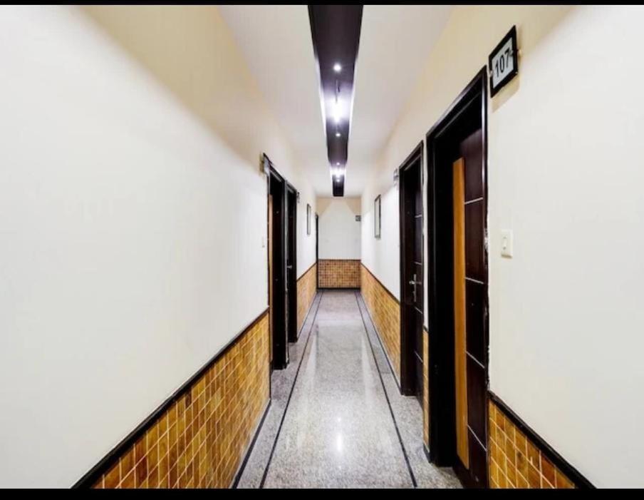 a corridor of a hallway with doors and tiles at Hotel MNG The Platinum in Kānpur