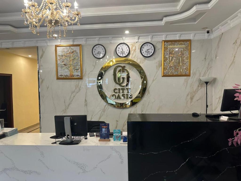 a lobby with clocks on the wall and a reception desk at City Oasis Boutique Hotel in Lahore