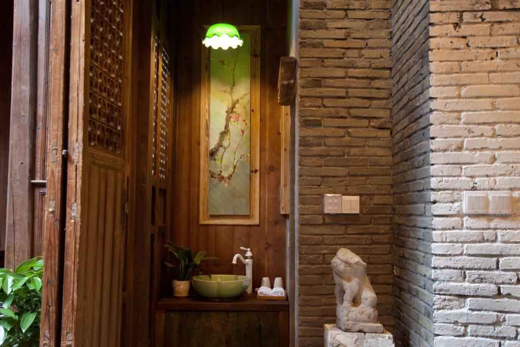 una statua di gatto seduta su uno scaffale accanto a un edificio di WuYuan QiYe YanXiang Guesthouse a Wuyuan