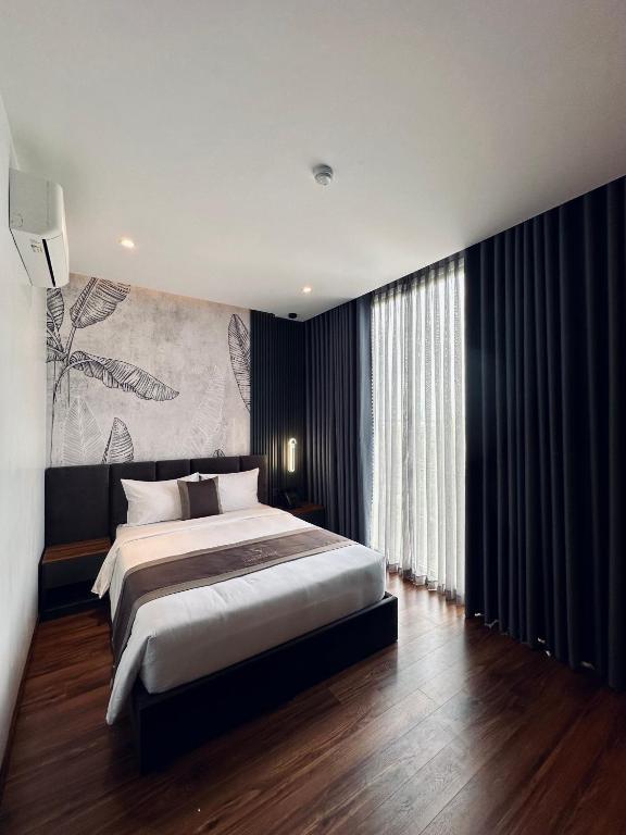 a bedroom with a large bed and a large window at LION 12 Hotel in Can Tho