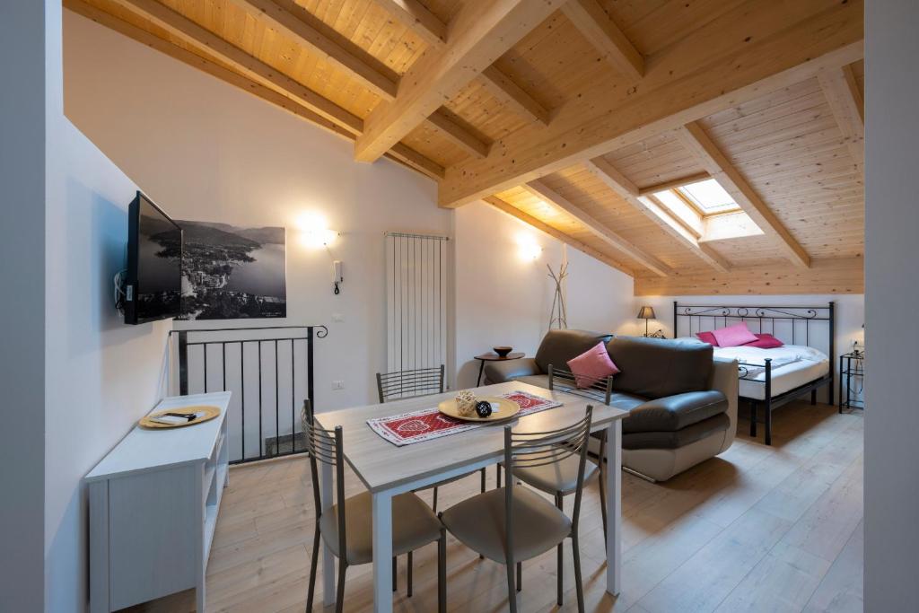 a living room with a table and a couch and a bed at Appartamento Bastione in Riva del Garda