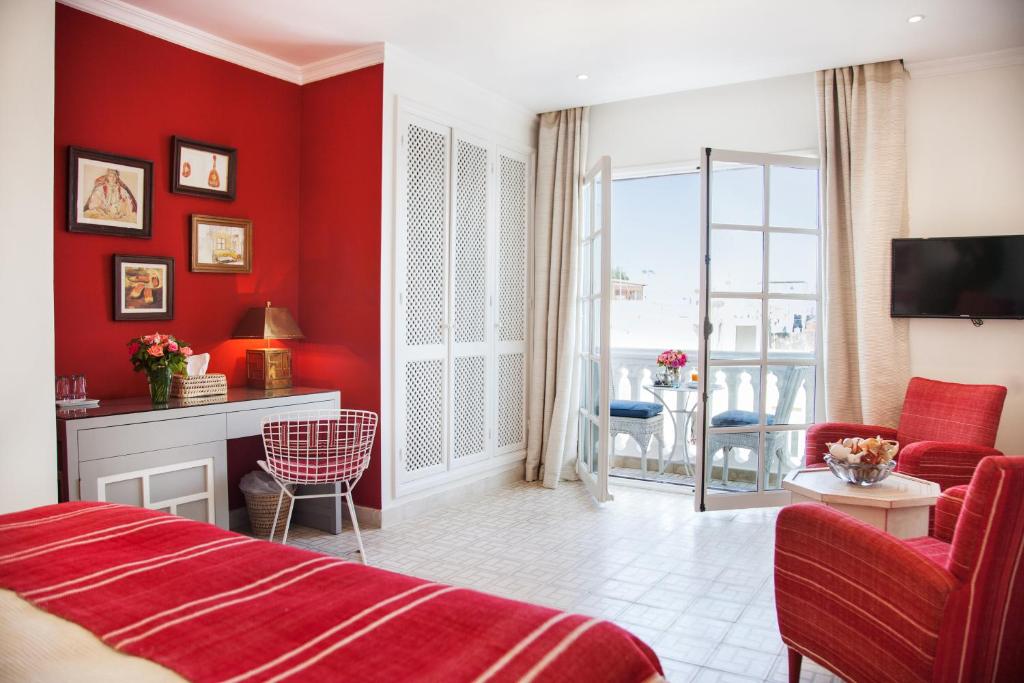 a red room with a bed and a living room at Riad Mokhtar in Tangier