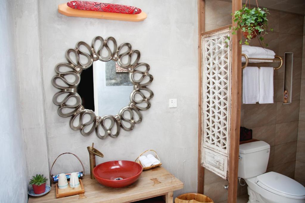 bagno con specchio, lavandino e servizi igienici di WuYuan QiYe YanXiang Guesthouse a Wuyuan