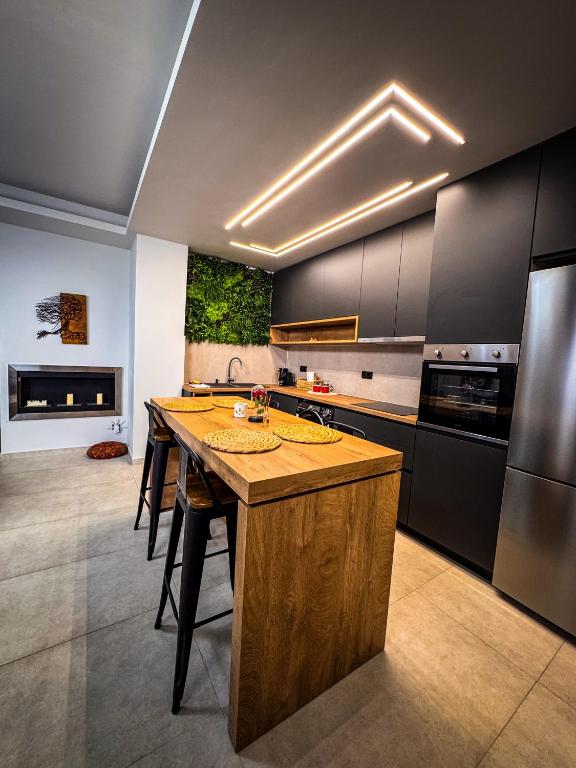 a kitchen with a wooden island in the middle at Siel simple elegance Volos in Volos