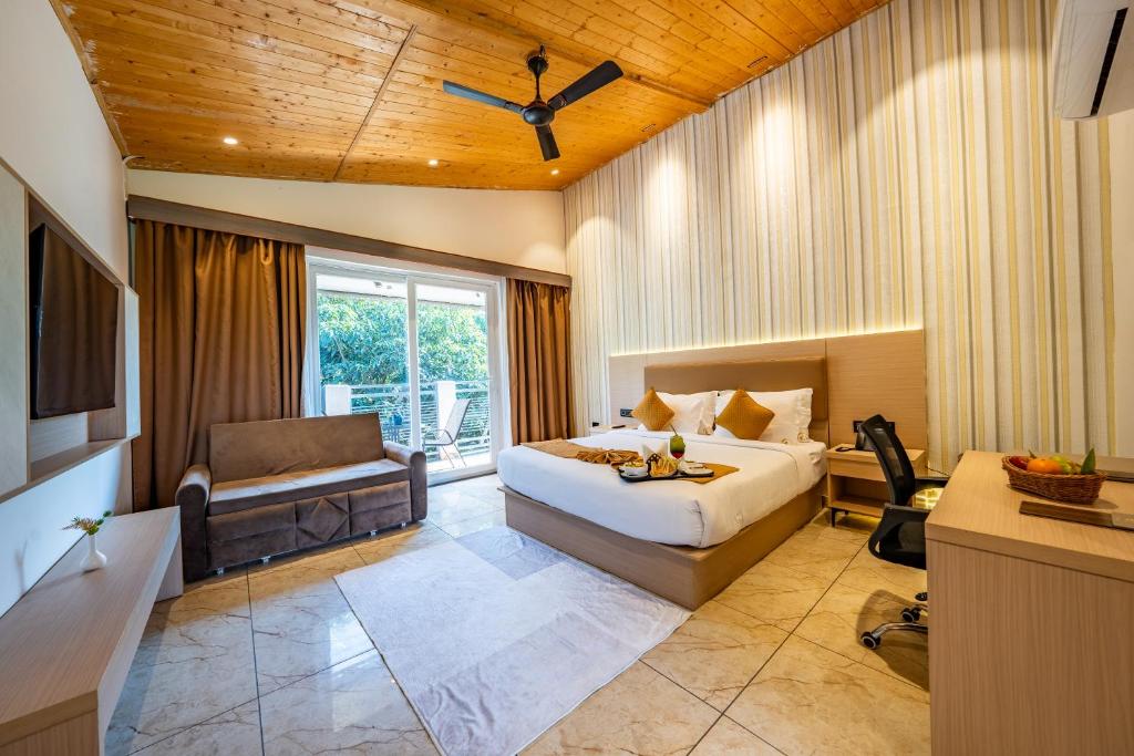 a hotel room with a bed and a couch at Leafy Lush Resort and Spa in Rāmnagar