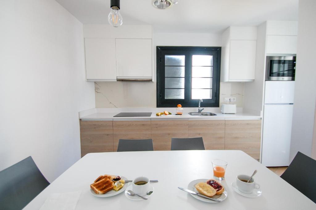 a kitchen with a table with two plates of food on it at Los Cardones Boutique Village in Playa de las Americas