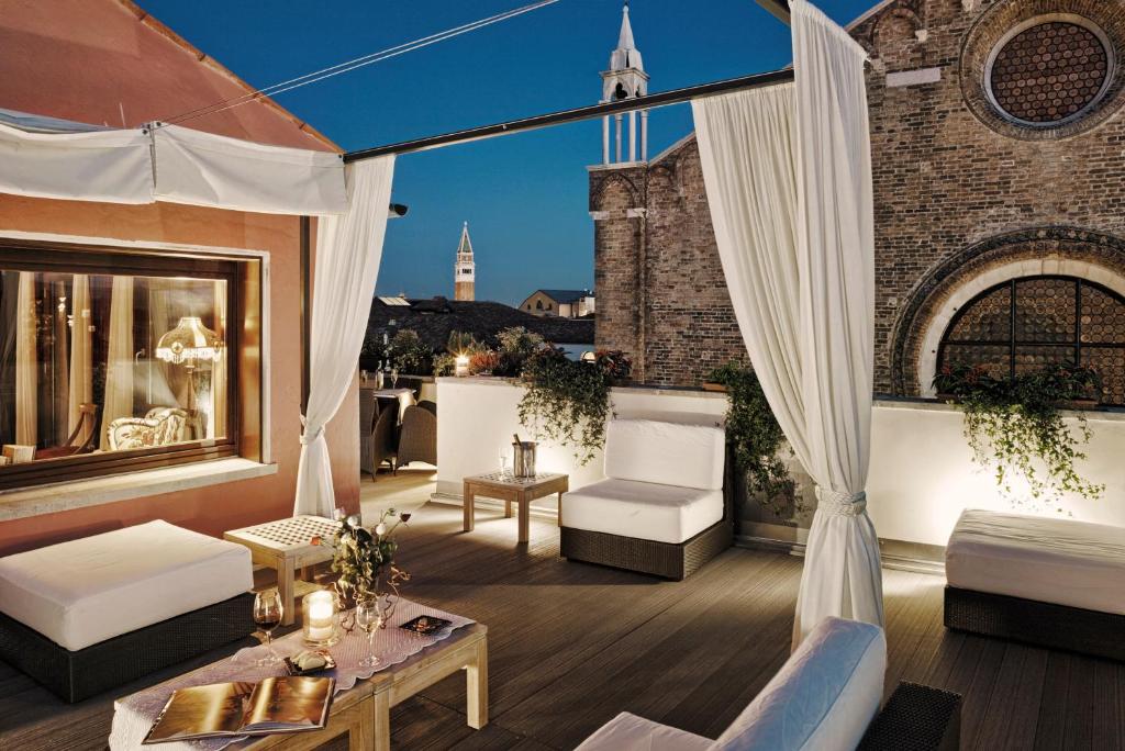 a rooftop patio with white furniture and a window at B&B Bloom Settimo Cielo in Venice