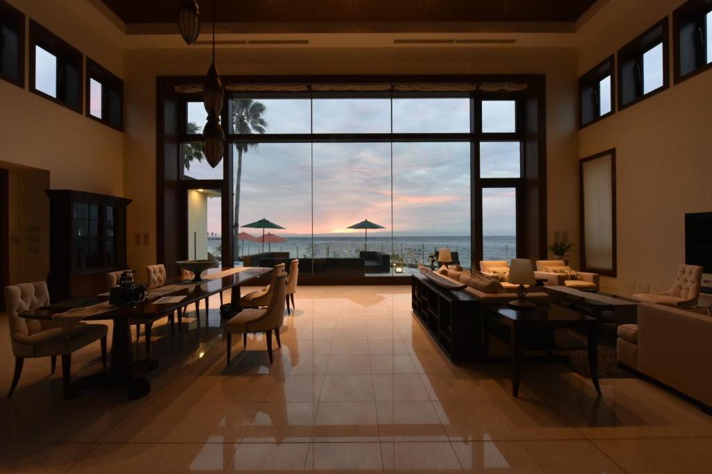 a dining room with tables and chairs and a large window at ヴィラモンタン・淡路 in Akashi