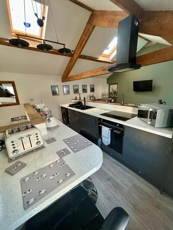 a kitchen with a table and a counter top at Red Rose Cottage in Cockermouth