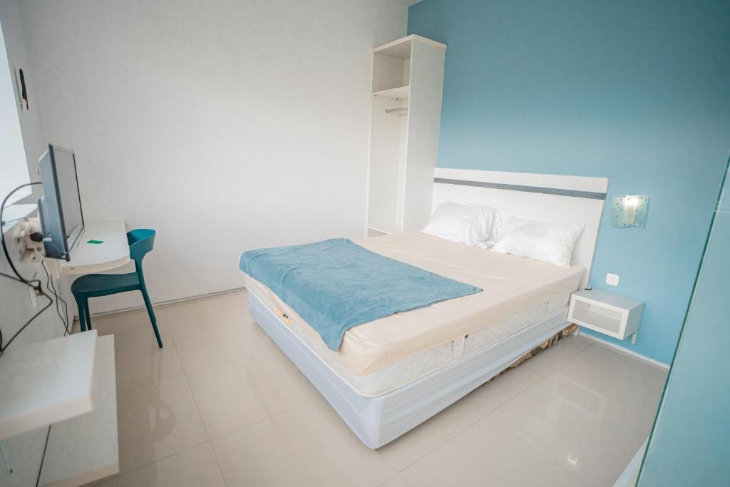 a hospital room with a bed and a desk at Hotel Pratisarawirya by The Loka in Surabaya