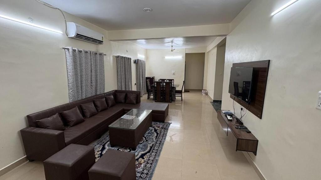 a living room with a couch and a tv at Elite Villa Raipur - Luxury Homestay in Raipur