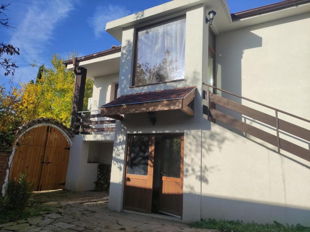 a house with a wooden door and a gate at къща за гости При Приятели in Nesebar