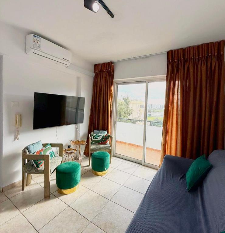 a living room with a bed and a flat screen tv at Carisa rooms for holiday in Larnaca