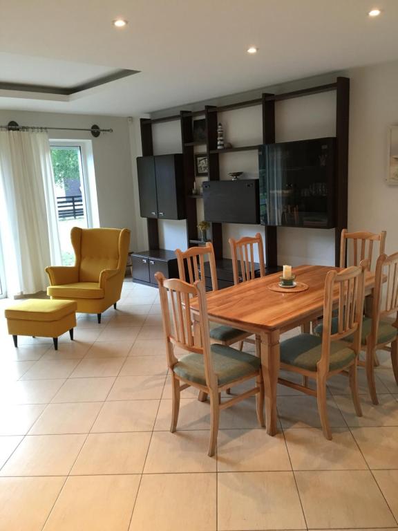 cocina y comedor con mesa de madera y sillas en AV villa, en Nida