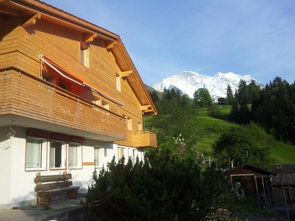 ein Holzhaus mit einem Berg im Hintergrund in der Unterkunft Chalet Viola - Verena's Loft in Wengen