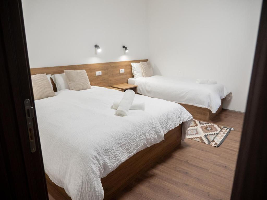 a bedroom with two beds with white sheets at Megdan prenočište in Požarevac