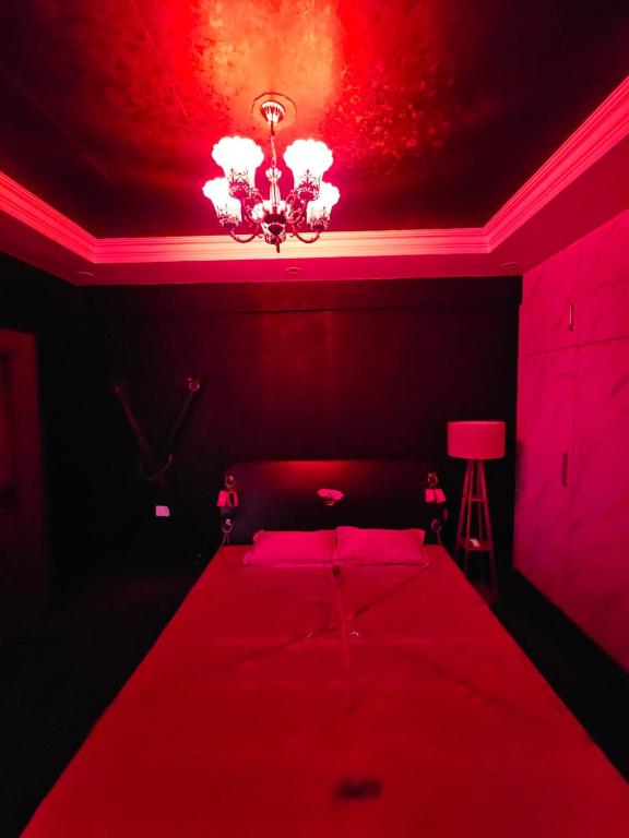 a red bedroom with a bed with a red ceiling at The Secret Escape in Bahādurgarh