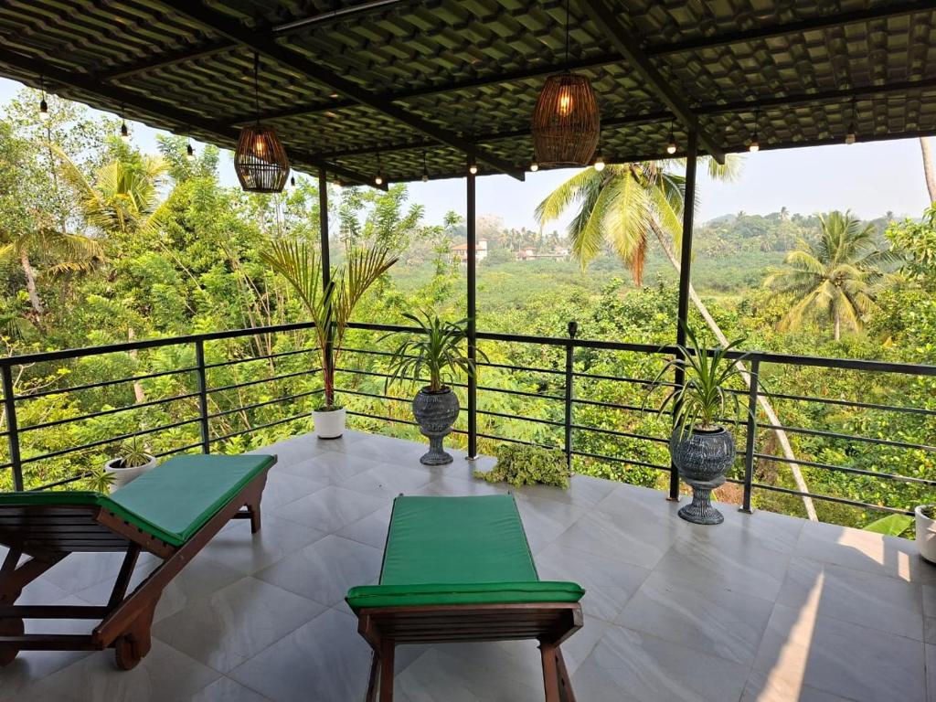 a porch with chairs and a view of a forest at Fair view in Induruwa