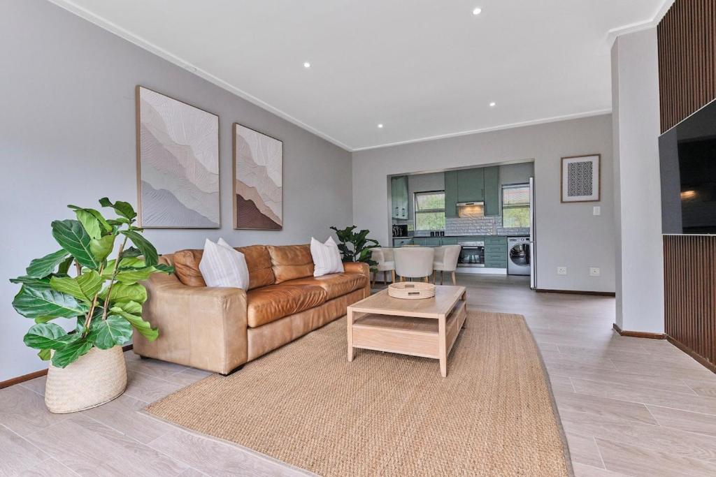 a living room with a couch and a table at Afrikaya Luxurious Apartment in Roodepoort