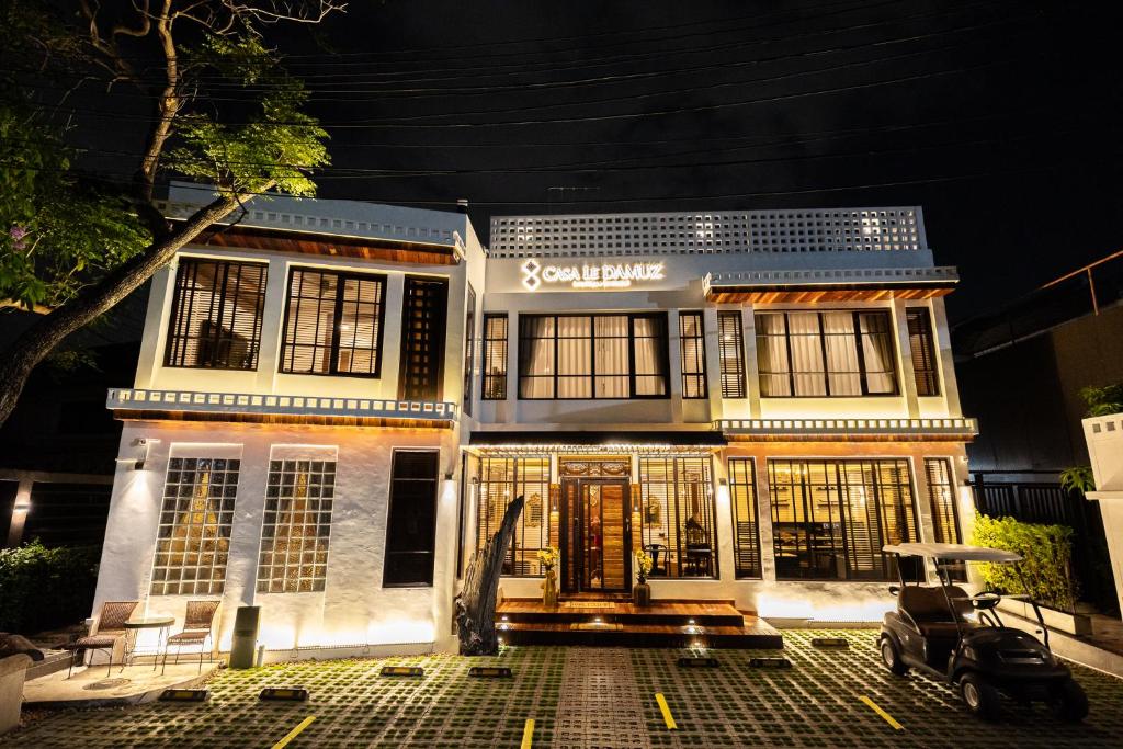 a house with a scooter parked in front of it at Casa Le Damuz At MRT Bangphlat - Adult Only in Bangkok