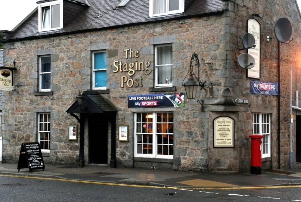 a stone building with a sign that reads the stepping post at The Staging Post in Aberdeen