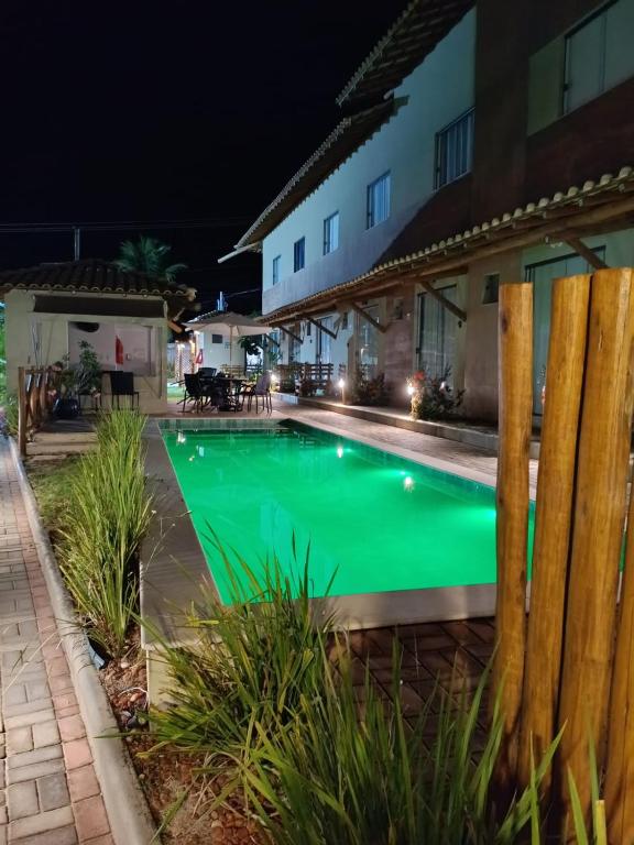a swimming pool in front of a house at night at Aconchego da Jandaia in Imbassai