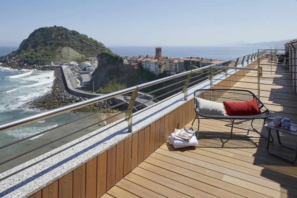 a chair sitting on a balcony overlooking the ocean at ATeRIAN GAZTETAPE II in Getaria