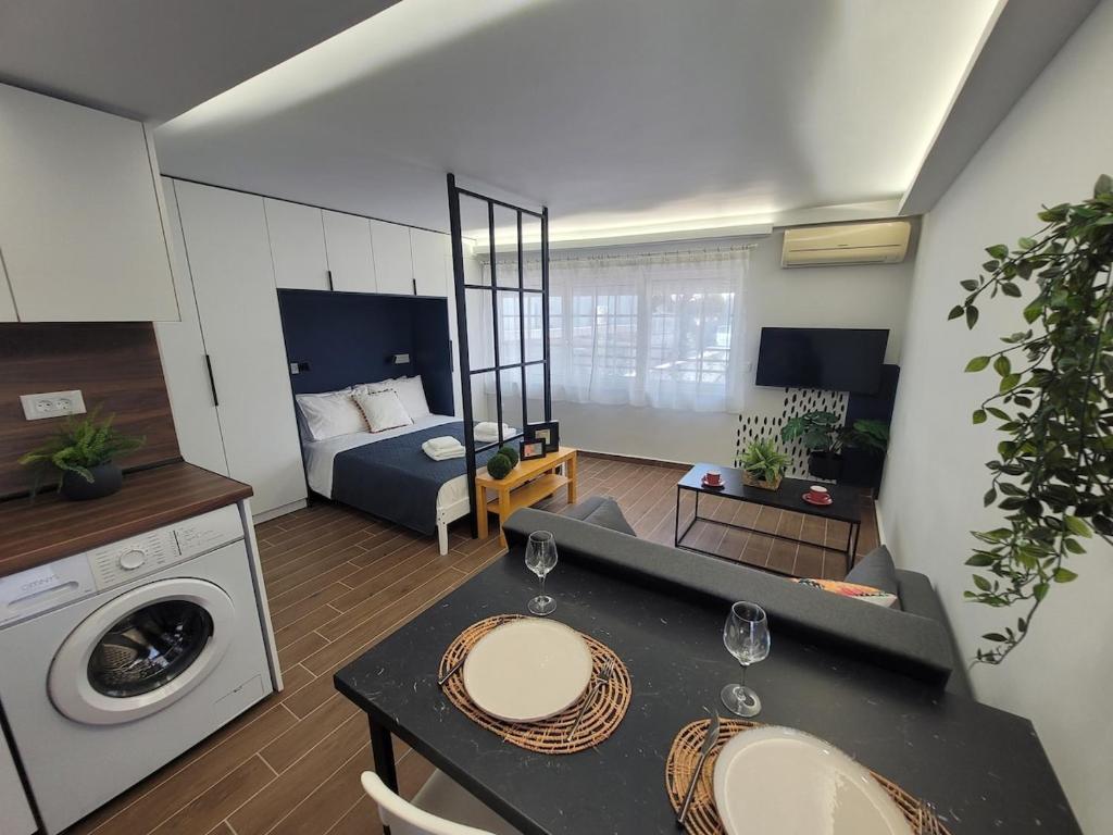 a living room with a bed and a table with a washing machine at Hyacinthus city apartment in Rhodes Town