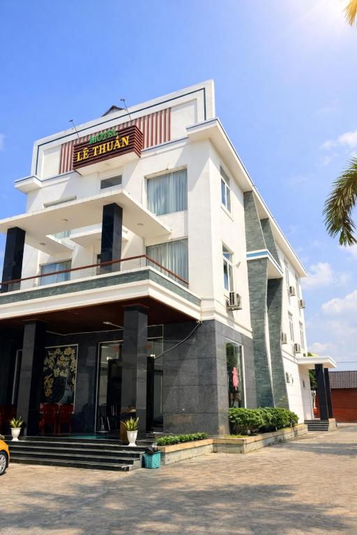 a large white building with a sign on it at Lê Thuận Hotel in Lai Vung