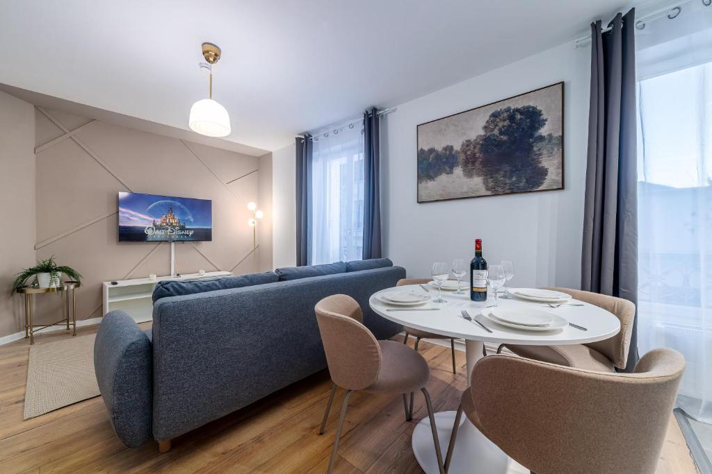 a living room with a blue couch and a table at Disney 12 min - Gare 5min à pied - Self check-in in Esbly