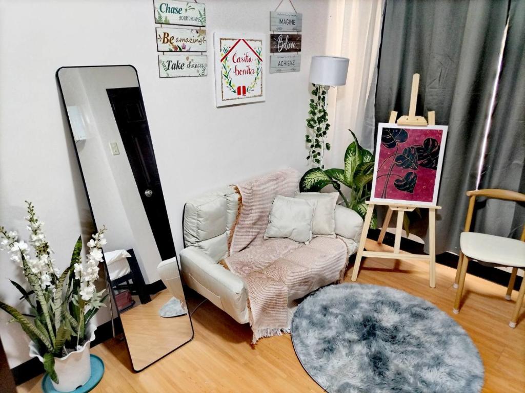 a living room with a chair and a mirror at Casita Bonita in Marilao
