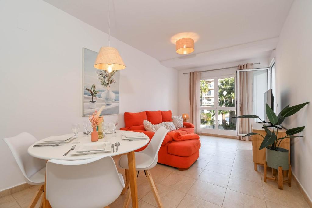 a living room with a table and a red couch at Apartment Happy Coast Moraira in Moraira
