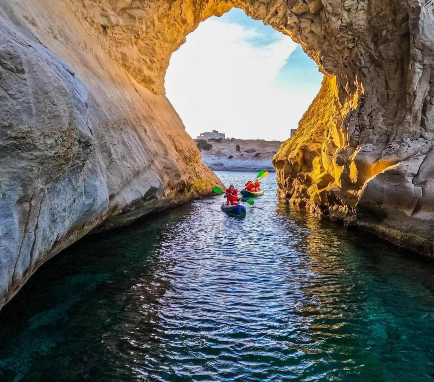 a group of people kayaking in a cave on the water at Sensi Hotel in Marsaskala