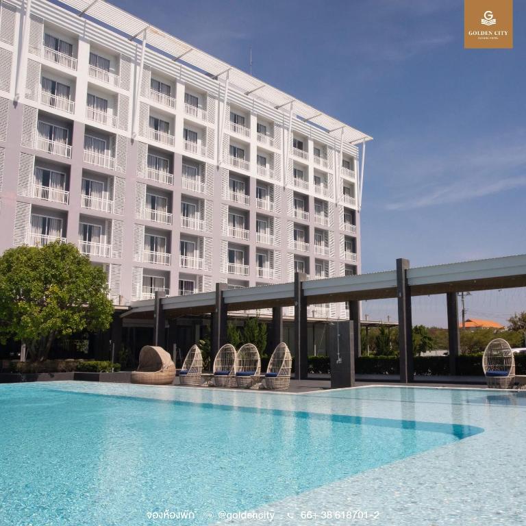 a hotel with a swimming pool in front of a building at Golden City Rayong Hotel in Rayong