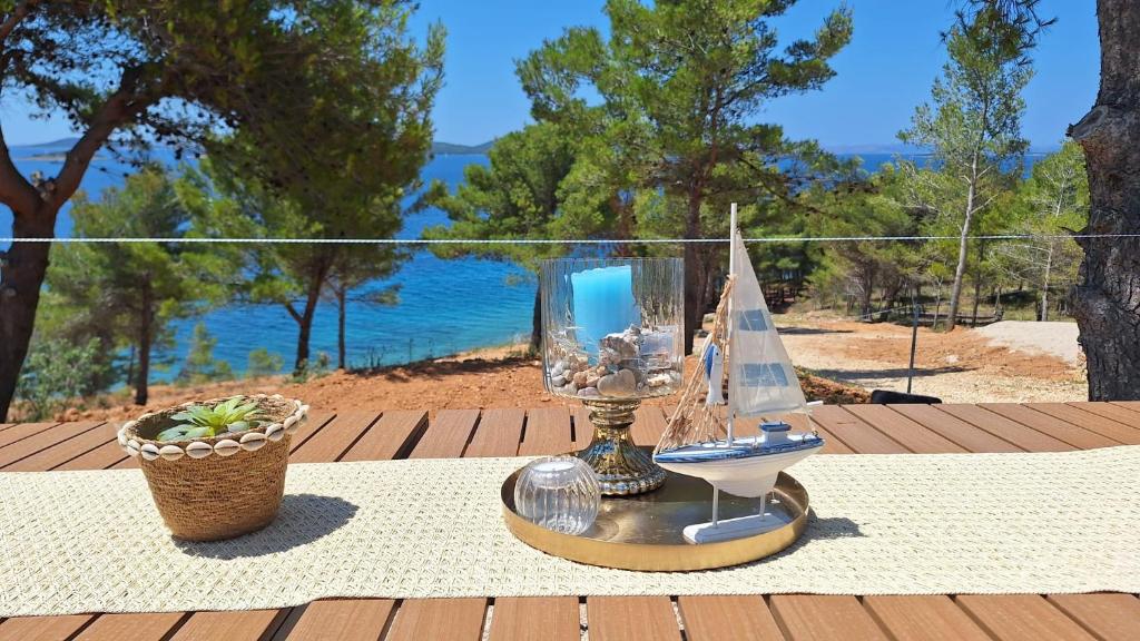a table with a model boat and a glass hurricane at Mobile home Clara in Drage