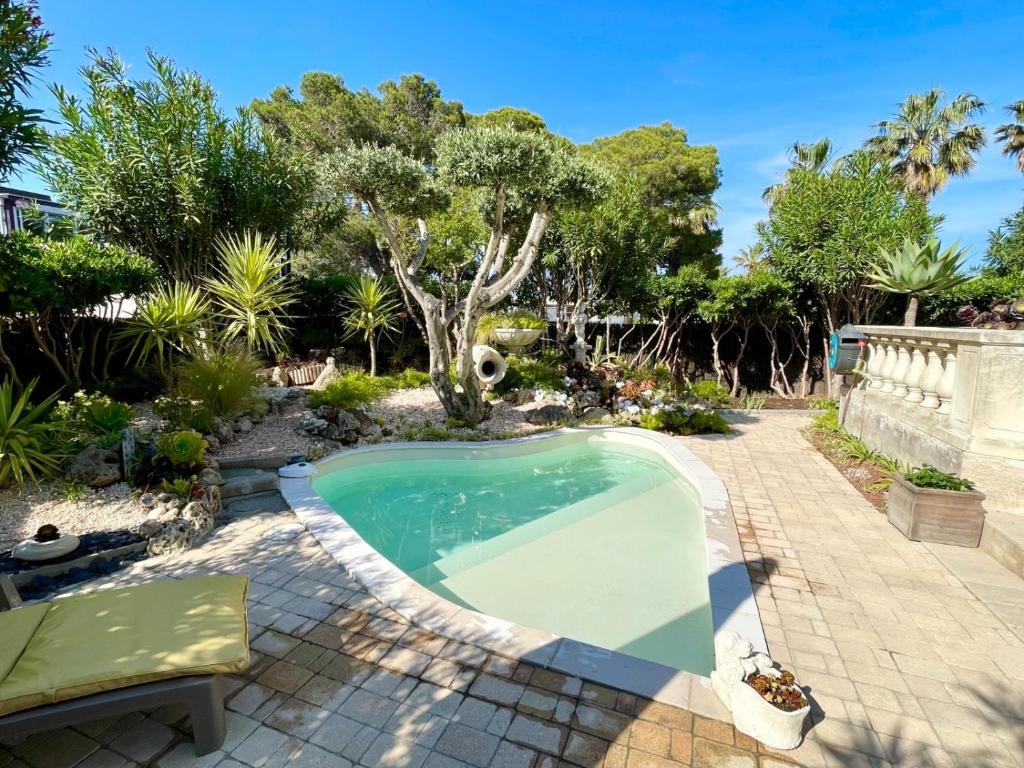 a swimming pool in a yard with trees at Maison Gecko - Proche de la plage in Cavalaire-sur-Mer