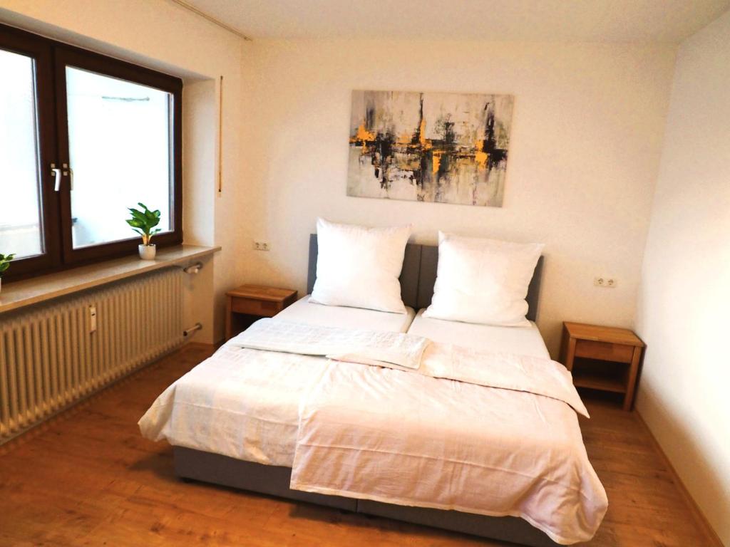 a bedroom with a large bed with two pillows at Gemütliche Maisonette nahe der längsten Burg der Welt in Burghausen