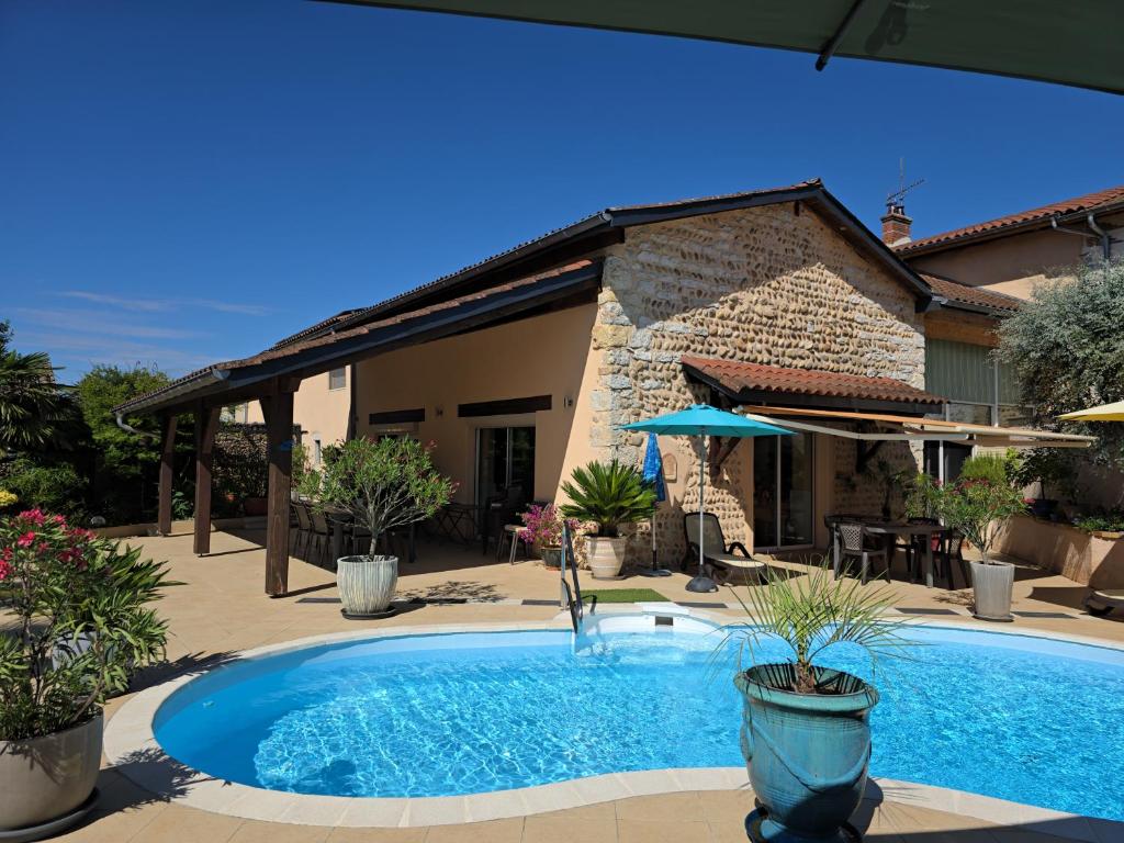 a swimming pool in front of a house at Chambres d hôtes Léonie in Druillat