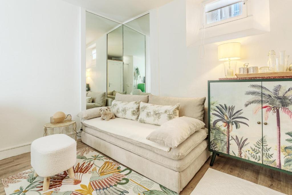 a living room with a couch and a mirror at Studio Cosy - Le Marais centre in Paris