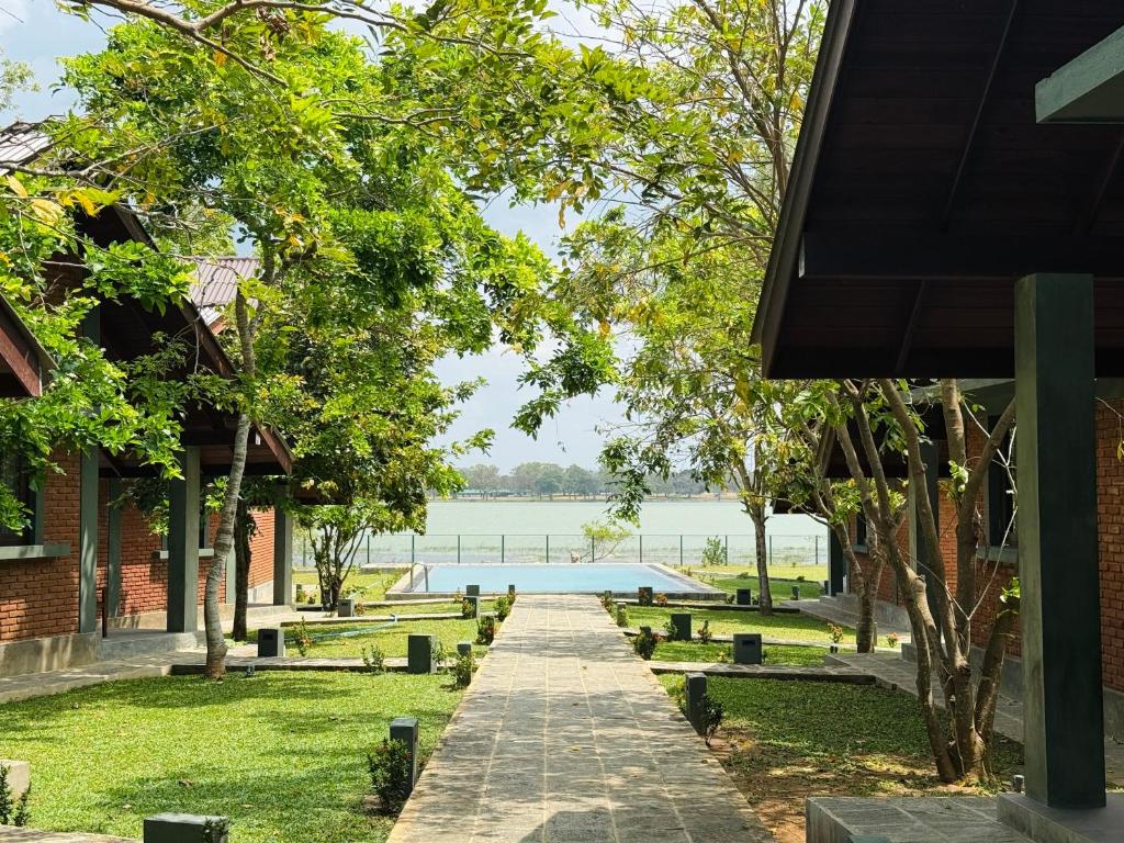 a walkway through a park with a body of water at Ranmin Lake Weerawila in Weerawila