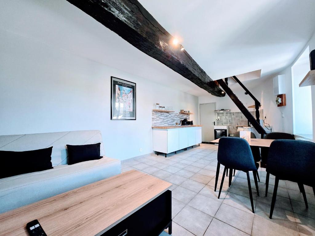 a bedroom with a bed and a table and chairs at La Croix Duplex - Bail Partner in Chablis