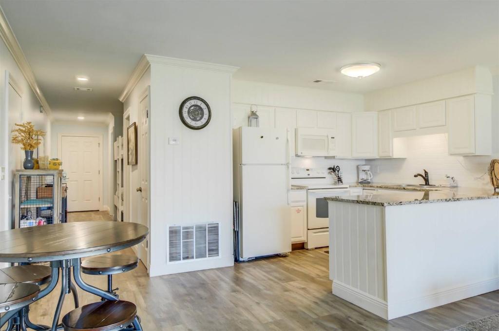 a kitchen with a white refrigerator and a table at 10 A, One Bedroom Condo in Destin