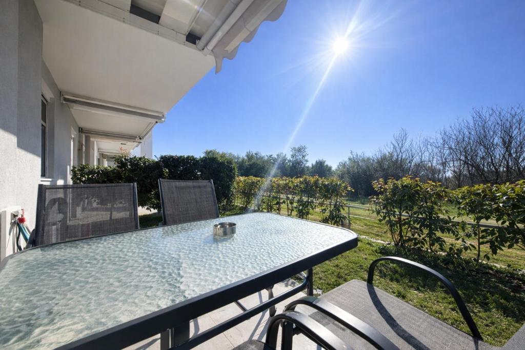 a table and chairs on a porch with a view at Danai & Palm Stay Complex by Horizon Homes in Ofrínion